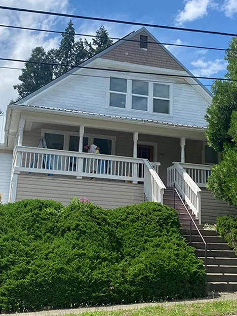 Before and after exterior house painting transforming a white home to green in Roseburg, OR